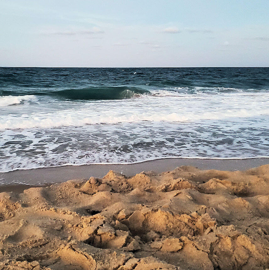 waves on beach rolling in on the beach by the shore.